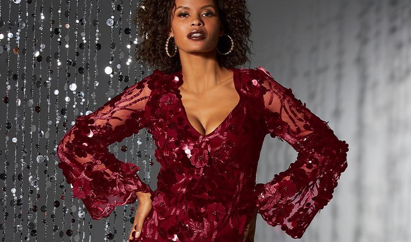 model wearing a red floral sequin illusion sleeve v-neck dress and pearl hoop earrings.