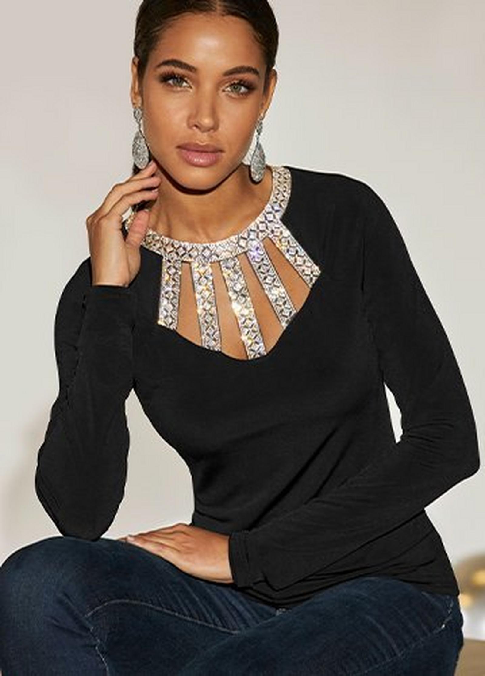model wearing a black long-sleeve rhinestone embellished top.