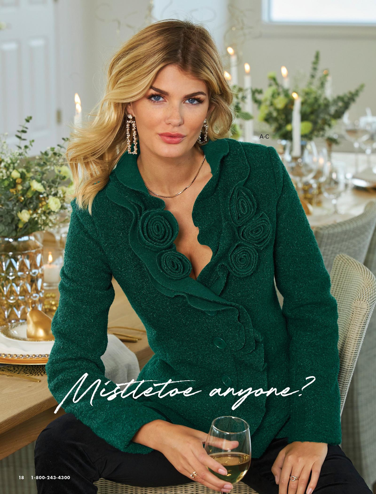 model wearing a green rosette cardigan and black pants.