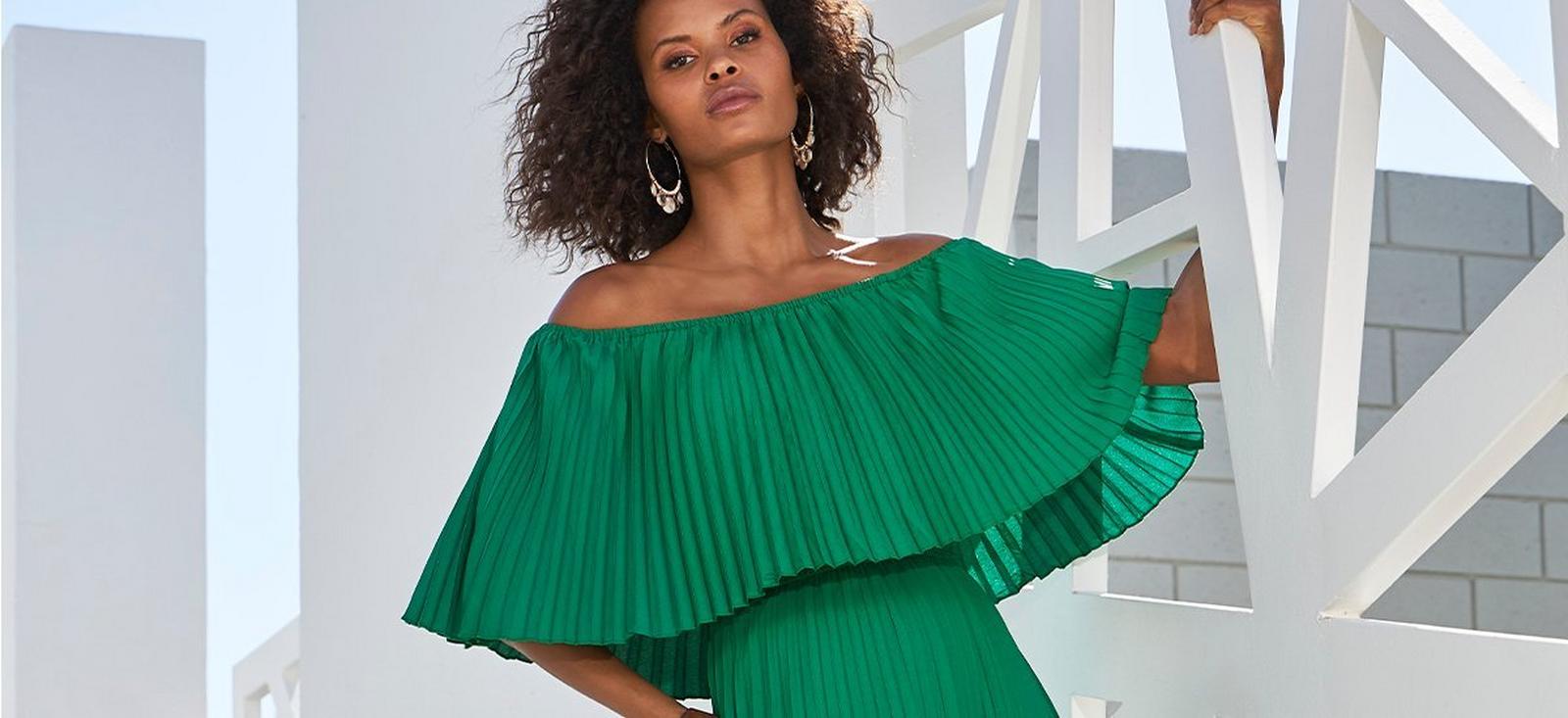 model wearing a green off-the-shoulder pleated maxi dress.