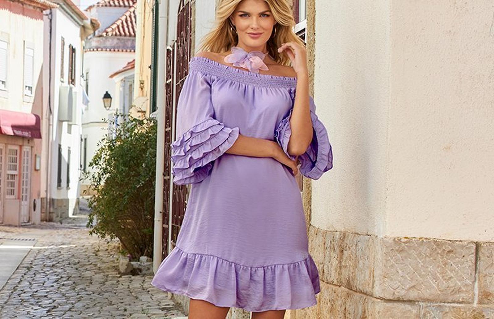 model wearing a lavender off-the-shoulder ruffle sleeve short dress and a pink and purple flower choker necklace.