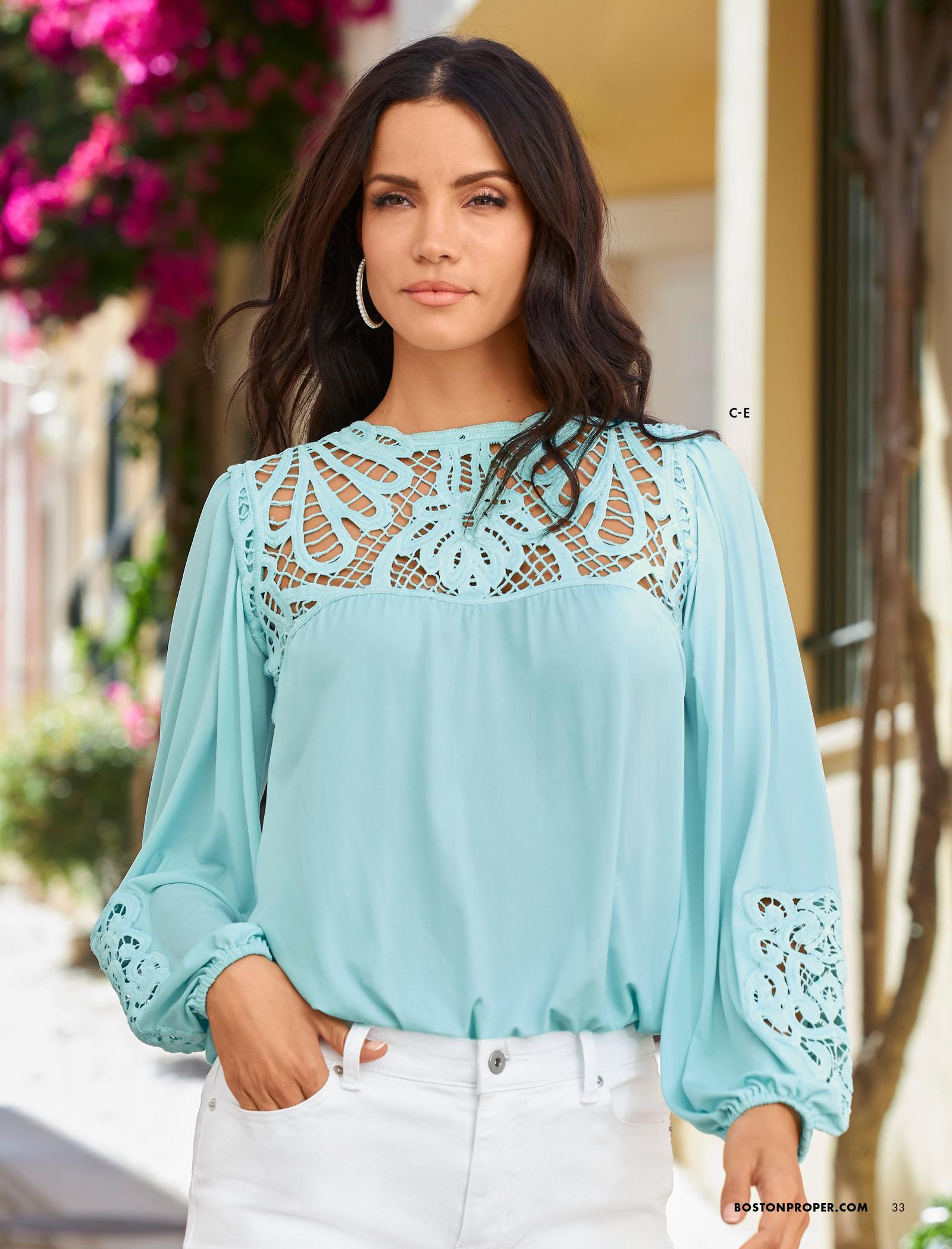 model wearing a light blue lace balloon sleeve blouson top and white jeans.