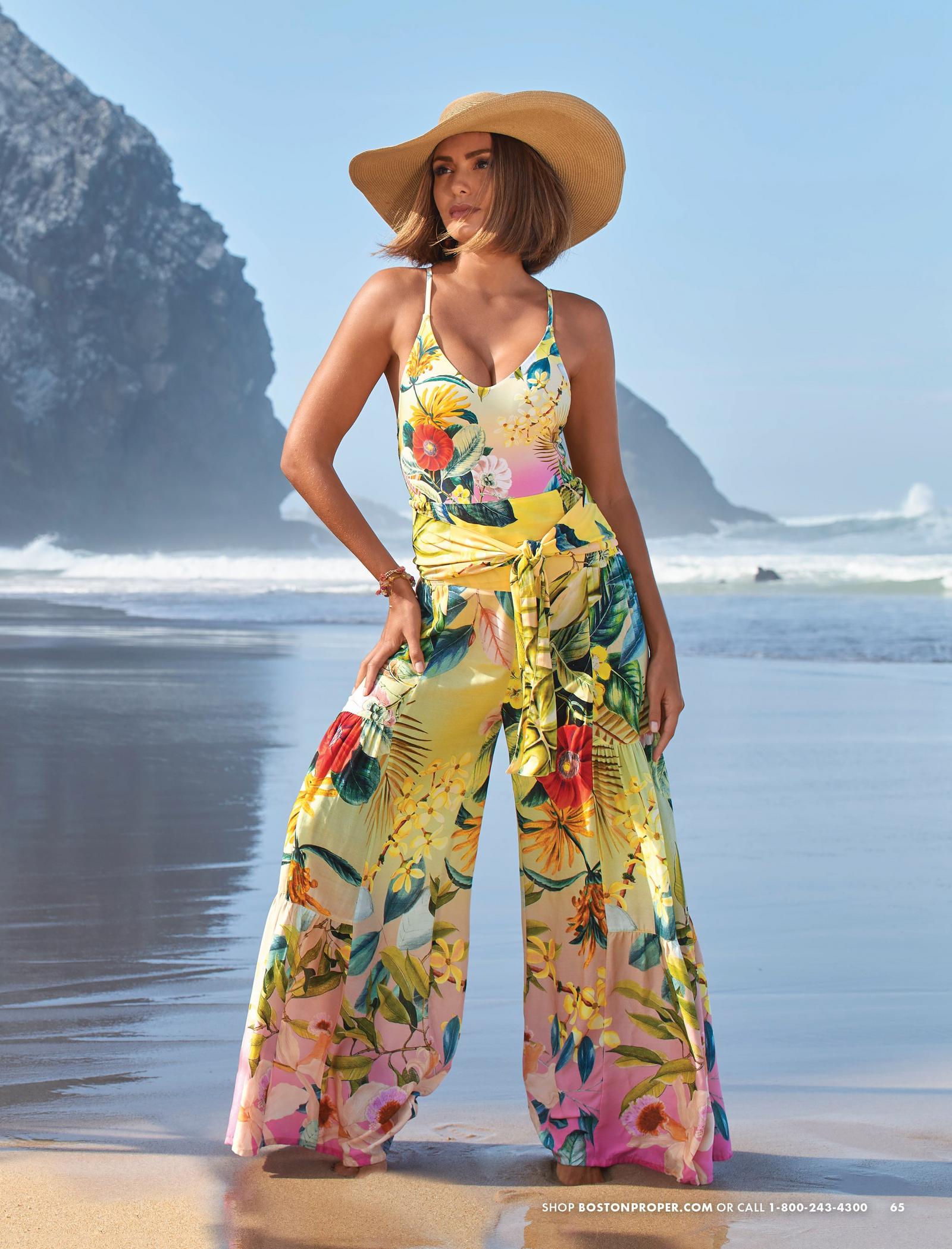 model wearing a floral printed v-neck one-piece swimsuit, matching palazzo cover-up pants, and a straw wide brim hat.