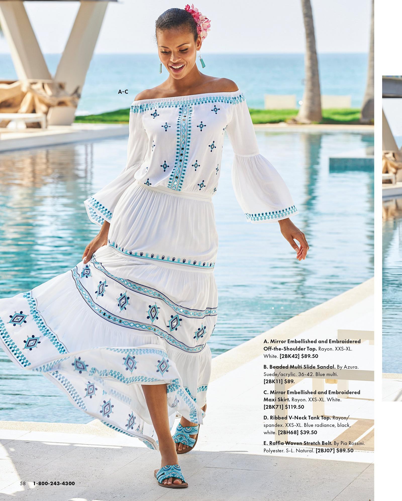 model wearing a blue and white mirror embellished off-the-shoulder flare sleeve top, matching maxi skirt, and blue beaded sandals.
