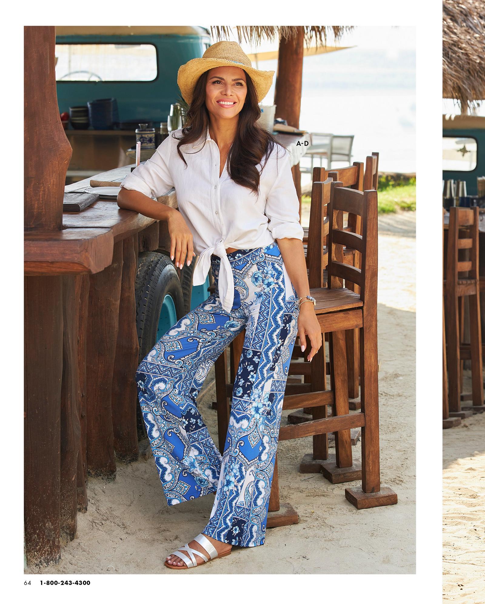 model wearing a white tie-front long-sleeve linen shirt, cowboy hat, blue tile print palazzo pants, and silver sandals.