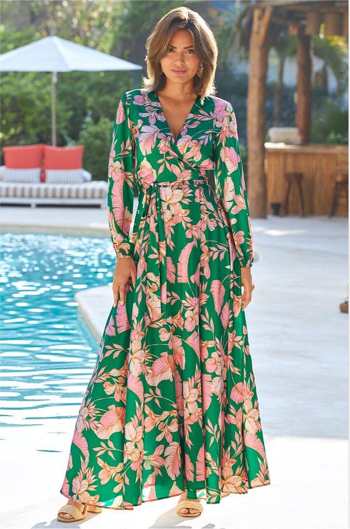 model wearing a green and pink floral long-sleeve maxi wrap dress.