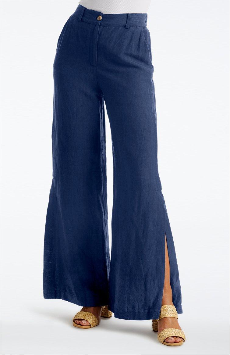 model wearing navy side-slit wide leg linen pants, white top, and raffia block heels.