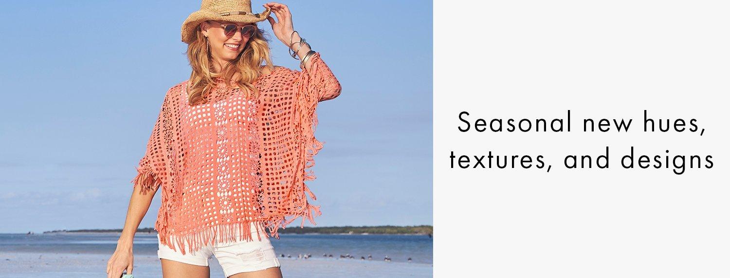 model wearing a pink crochet poncho, white tank top, white denim shorts, and embellished straw hat.